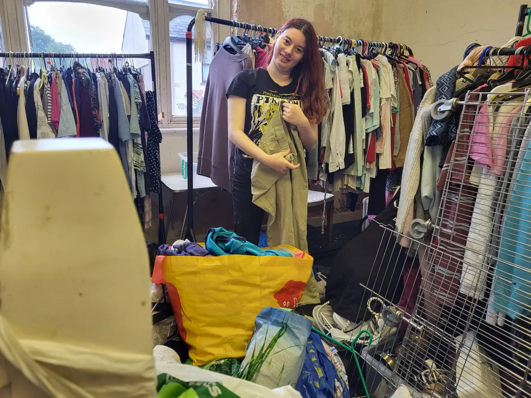 Photo from Jayne's Baby Bank (main page), 1 Sep 2024: Chloe hanging up the £1 clothes in our pound shop level