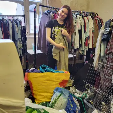 Image from Jayne's Baby Bank (main page), 1 Sep 2024: Chloe helping us hang up the £1 shop clothes in Pontypool
