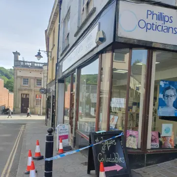 Photo from Jayne's Baby Bank (main page), 15 May 2025: Pmsl! The opticians sign is falling off! We have not been arrested! Hahaha me and Eli were going to stage this last week and have crime scen